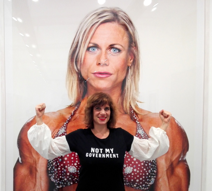Beatrix Roidinger von E.R.O.S. & du in einem Shirt von Modus Vivendi vor einem Foto aus der Serie 'Female Bodybuilder', Bild (c) Claudia Busser - kekinwien.at Beatrix Roidinger von E.R.O.S. & du in einem Shirt von Modus Vivendi vor einem Foto aus der Serie 'Female Bodybuilder', Bild (c) Claudia Busser - kekinwien.at